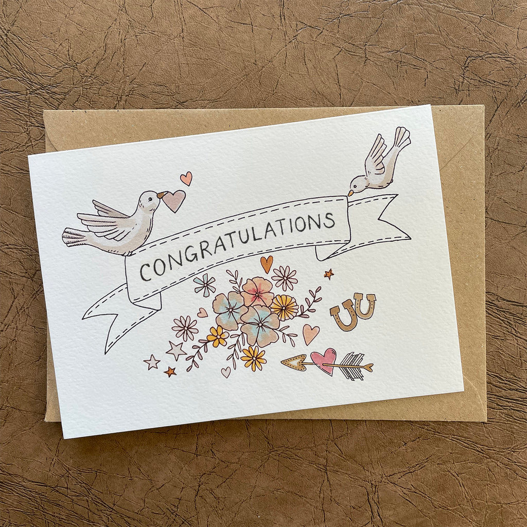 Greeting card with illustrated 'Congratulations' text and love/wedding themes decorative elements on an off-white background. Card blank inside.